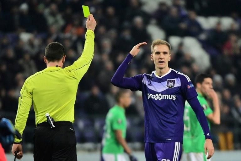 Anderlecht's forward Lukasz Teodorczyk (R) reacts after receiving a yellow card during the UEFA Europa League football match against Saint-Etienne December 8, 2016