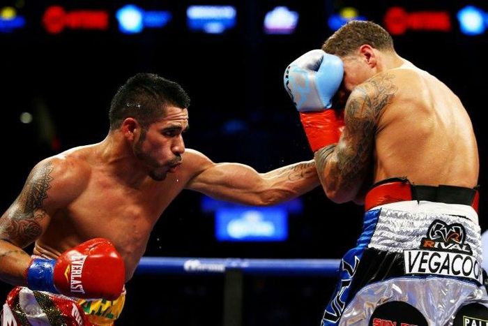 Jesus Cuellar (L) of Argentina punches Jonathan Oquendo of Puerto Rico during their WBA Featherweight Championship bout on December 5, 2015 in New York City