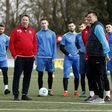 Sutton United's English manager Paul Doswell (R) and former Arsenal player Paul Merson (2L) stand on the pitch with the players during a team training session in Sutton, sout-west London, on February 16, 2017