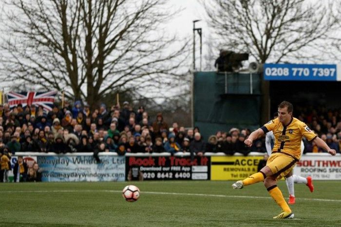 Sutton United defender Jamie Collins scores the opening goal from the penalty spot during the English FA Cup match between Sutton United and Leeds United at the Borough Sports Ground in London on January 29, 2017