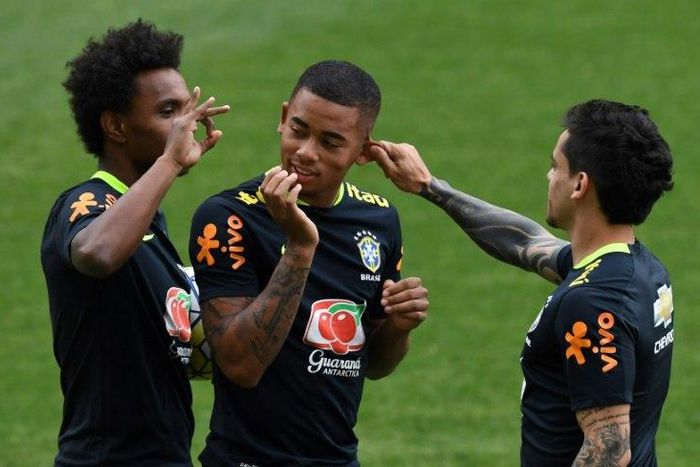 Brazil international footballer Gabriel Jesus (C) jokes with teammates Willian (L) and Vagner during a training session in Belo Horizonte, Minas Gerais, Brazil, on November 7, 2016