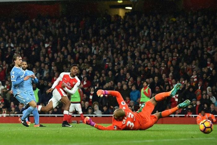 Arsenal's Alex Iwobi (3L) shoots and scores past Stoke City's goalkeeper Lee Grant at the Emirates Stadium in London