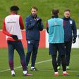 England's interim manager Gareth Southgate talks to his players during training while sporting one of the commemorative poppies that are banned from matches under FIFA rules