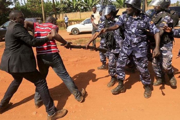 A supporter of Uganda's former Prime Minister Amama Mbabazi wrestles with the gun of a policeman, as riot police disperse a gathering in Jinja town in eastern Uganda September 10, 2015.  REUTERS/James Akena