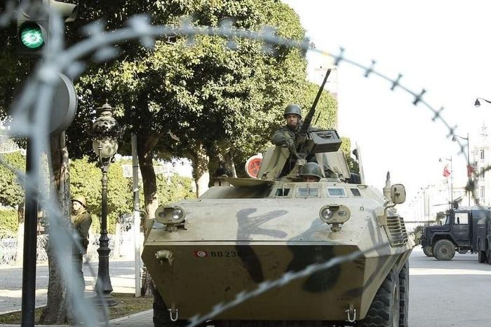 An army soldier stands guard behind a wire fence cordon outside the interior minister's office in Tunis February 7, 2011. REUTERS/Zoubier Souissi