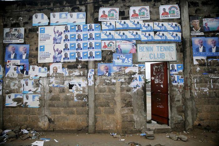 Election posters are seen pasted on a wall at the entrance to Benin Tennis Club, a day before the presidential election in Cotonou, March 5, 2016. REUTERS/Akintunde Akinleye