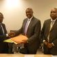 Henry Kerali, World Bank Country Director for Ghana  exchanging signed agreement with  Patrick Awuah, President of Ashesi, looking on is Mr Fredua Agyeman, Director of Environment, Ministry of Environment, Science, Technology and Innovation Climate