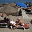 Tourists sunbathe on a beach in Fuengirola, on Costa del Sol, southern Spain, July 12, 2015.