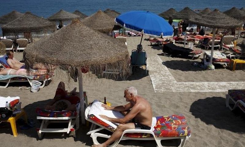 Tourists sunbathe on a beach in Fuengirola, on Costa del Sol, southern Spain, July 12, 2015.
