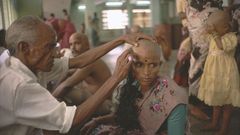 A devotee gets her head tonsured at the temple of Tirumala in Andhra Pradesh. The hair is collected, sorted, resold and then used in wigs and hair extensions.