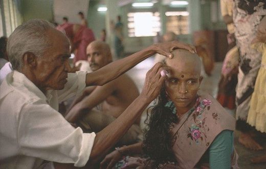 A devotee gets her head tonsured at the temple of Tirumala in Andhra Pradesh. The hair is collected, sorted, resold and then used in wigs and hair extensions.