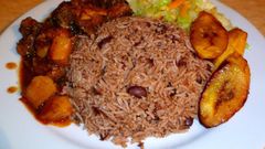 Waakye with chicken stew, fried plantain and steamed cabbage
