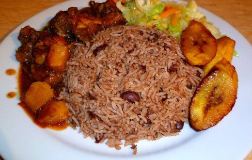 Waakye with chicken stew, fried plantain and steamed cabbage