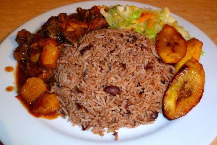 Waakye with chicken stew, fried plantain and steamed cabbage