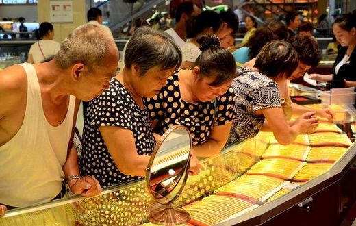 Customers look at gold necklaces at a jewelry store in Xuchang, Henan province, August 12, 2015.