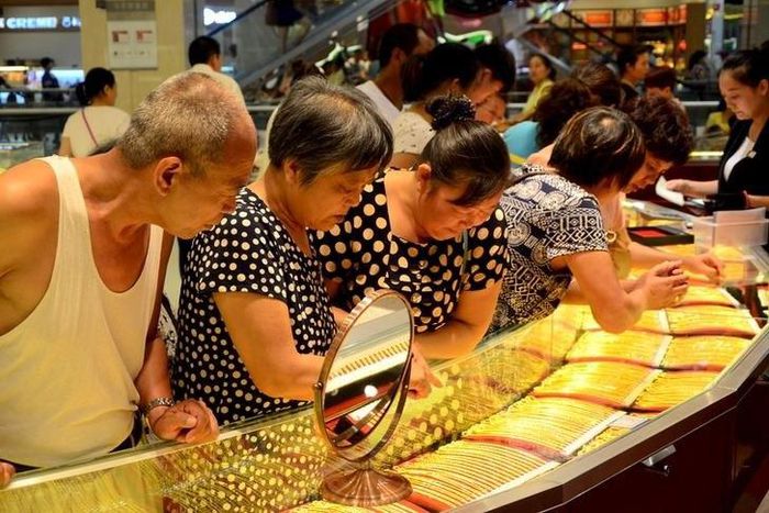 Customers look at gold necklaces at a jewelry store in Xuchang, Henan province, August 12, 2015.