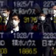 Pedestrians wearing masks are reflected in an electronic board showing various stock prices outside a brokerage in Tokyo, Japan, February 26, 2016.