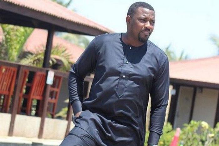 John Dumelo standing by a pool