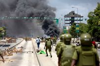 Riot police disperse demonstrators during violent protests in Dar es Salaam, Tanzania, on Wednesday, after the two leading opposition candidates were disqualified from the presidential election. Onsase Ochando/Reuters