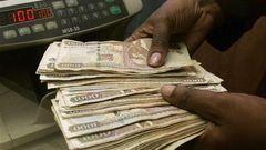 A currency dealer counts Kenya shillings at a money exchange counter in Nairobi  in a file photo.   REUTERS/Antony Njuguna