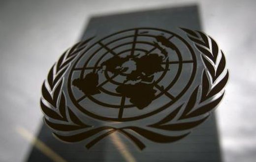 The United Nations headquarters building is pictured though a window with the UN logo in the foreground in the Manhattan borough of New York August 15, 2014.