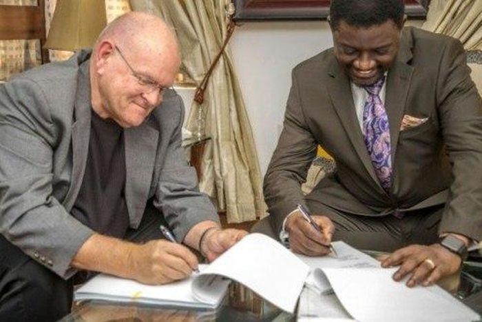Bishop Mills and Bishop Charles Agyinasare signing the takeover documents