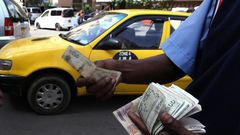 A fuel attendant handles Kenyan shilling notes at a petrol station in the capital Nairobi March 15, 2011.  REUTERS/Noor Khamis