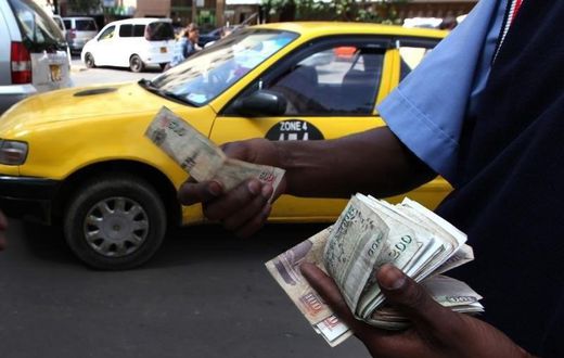 A fuel attendant handles Kenyan shilling notes at a petrol station in the capital Nairobi March 15, 2011.  REUTERS/Noor Khamis