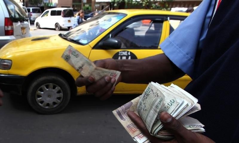A fuel attendant handles Kenyan shilling notes at a petrol station in the capital Nairobi   REUTERS/Noor Khamis