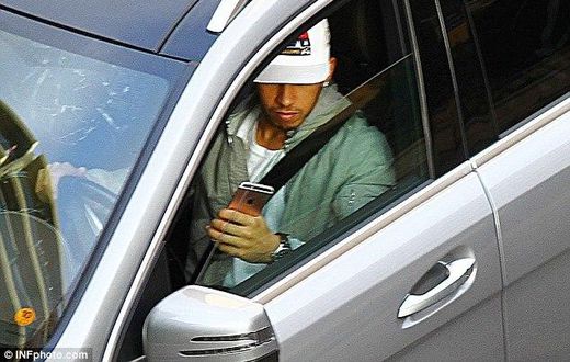 Lewis Hamilton driving and playing with his phone