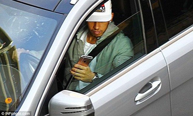 Lewis Hamilton driving and playing with his phone