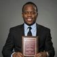 Adolph Okine, Ph.D. Student in Actuarial Science, Risk Management, and Insurance, holds his recent Best Paper Award.