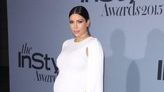 Kim Kardashian shows off bump in white floor length Valentino cape dress