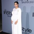 Kim Kardashian shows off bump in white floor length Valentino cape dress