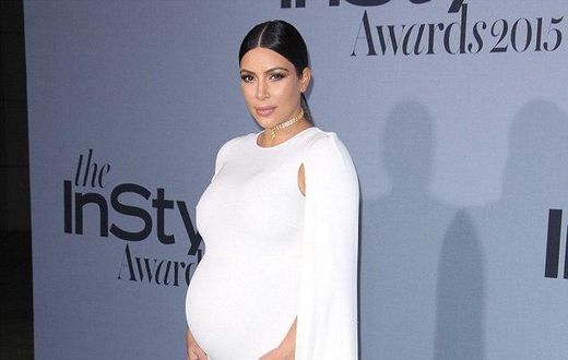 Kim Kardashian shows off bump in white floor length Valentino cape dress