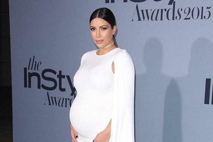 Kim Kardashian shows off bump in white floor length Valentino cape dress