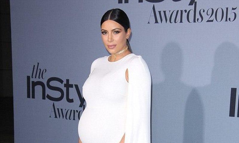 Kim Kardashian shows off bump in white floor length Valentino cape dress
