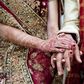 Bride and groom in traditional Indian wedding clothing with henna tattoos