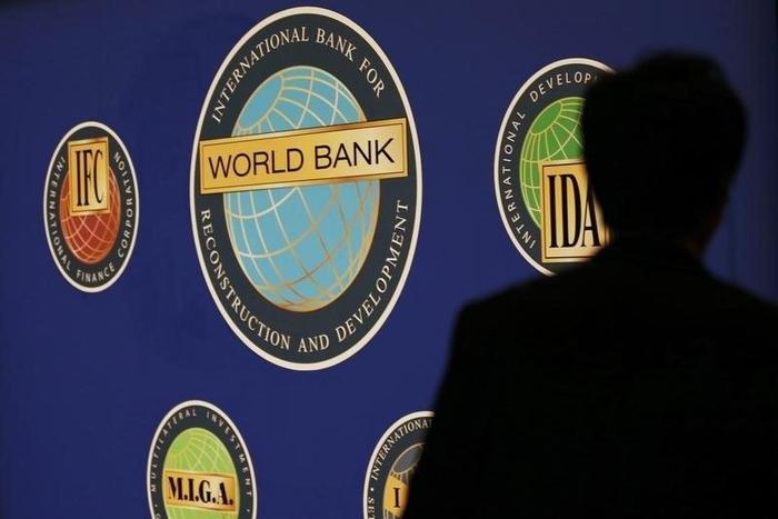 A man is silhouetted against the logo of the World Bank at the main venue for the International Monetary Fund (IMF) and World Bank annual meeting in Tokyo October 10, 2012.   REUTERS/Kim Kyung-Hoon