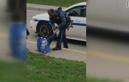 Picture of Black police officer tying boy’s shoe goes viral