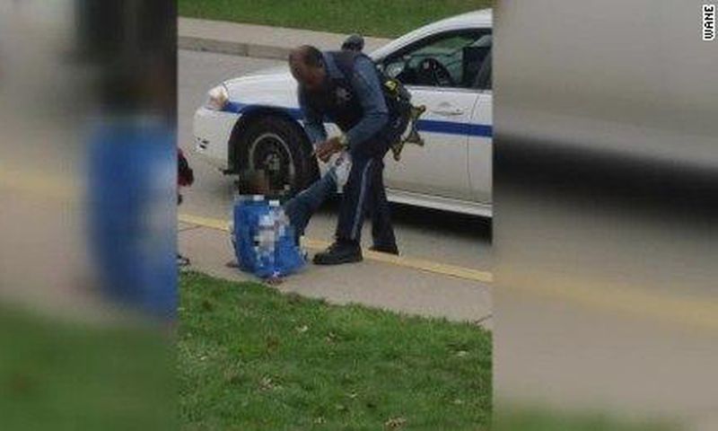 Picture of Black police officer tying boy’s shoe goes viral