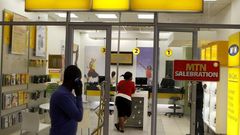 A man speaks on a mobile phone as he walks past a MTN shop at a shopping mall south of Johannesburg June 6, 2012.     REUTERS/Siphiwe Sibeko