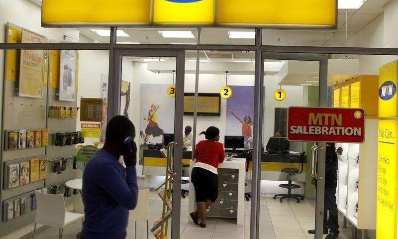 A man speaks on a mobile phone as he walks past a MTN shop at a shopping mall south of Johannesburg June 6, 2012.     REUTERS/Siphiwe Sibeko