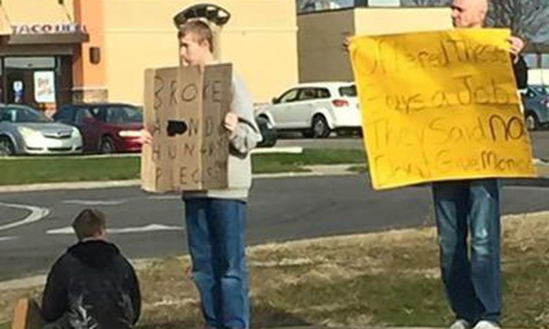 Mike Pothoff beside the panhandlers holding his sign
