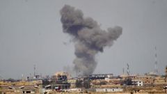 A plume of smoke rises above a building during an air strike in Tikrit March 27, 2015.