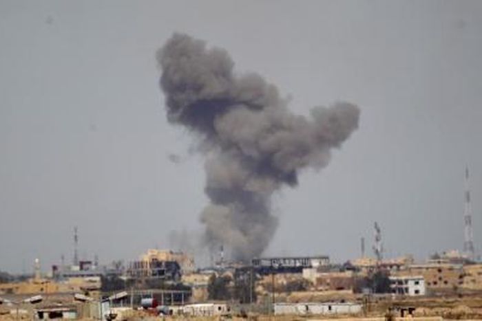 A plume of smoke rises above a building during an air strike in Tikrit March 27, 2015.