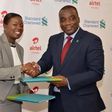 Managing Director of Airtel Ghana  Lucy Quist exchanging files with CEO of Standard Chartered Bank  Mr. Kweku Bedu-Addo