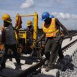 Men work on a train track at the National Arts Theatre stop of the light rail system under construction in Lagos, Nigeria, May 30, 2014.    REUTERS/Joe Penney