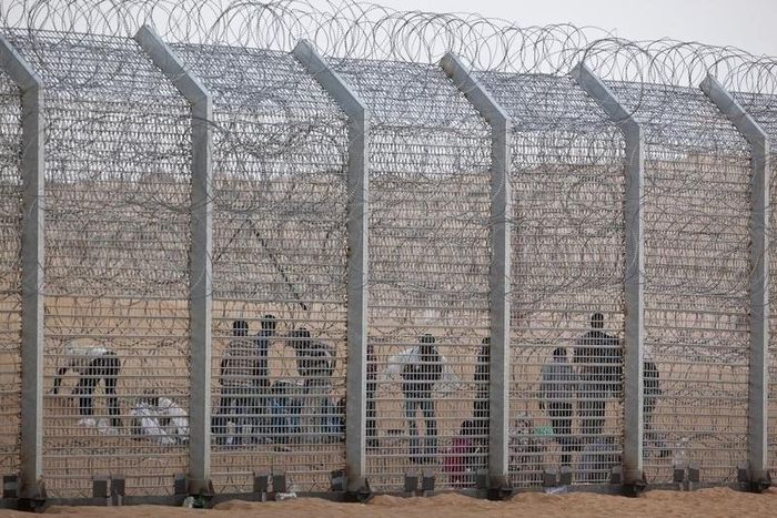 African would-be immigrants stand near the border fence between Israel and Egypt near the Israeli village of Be'er Milcha in a file photo. REUTERS/ Nir Elias