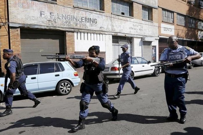 Police officers fire rubber bullets as they disperse African immigrants who are carrying machetes in Johannesburg, April 17, 2015 REUTERS/Siphiwe Sibeko